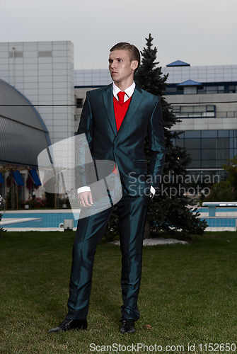 Image of Portrait of an attractive young businessman in urban background wearing suit and necktie. Looking to the camera. Classic style.