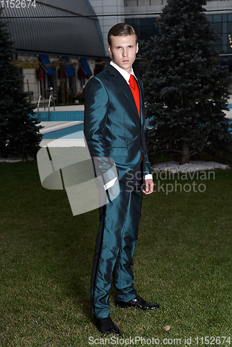 Image of Portrait of an attractive young businessman in urban background wearing suit and necktie. Looking to the camera. Classic style.