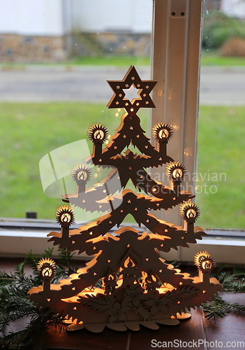 Image of Illuminated plywood Christmas tree against the window