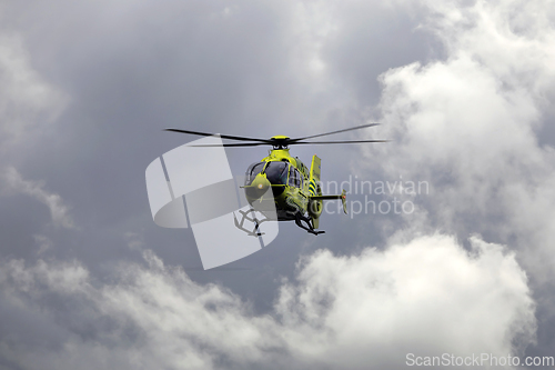 Image of FinnHEMS Medical Helicopter Against Dramatic Cloudy Sky