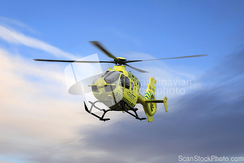 Image of FinnHEMS Medical Helicopter Against Blue Sky with Clouds