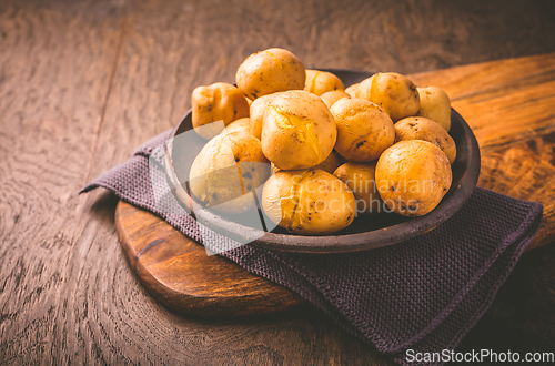 Image of Boiled young potatoes in bowl on cutting board