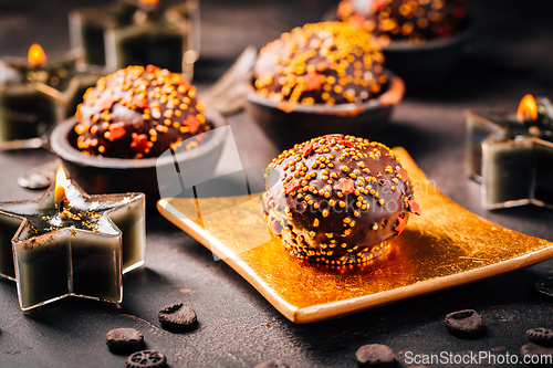 Image of Small chocolate pastry cakes for Christmas with candles and ornaments