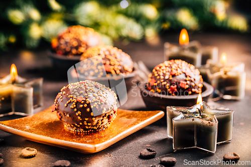 Image of Small chocolate pastry cakes for Christmas with candles and ornaments