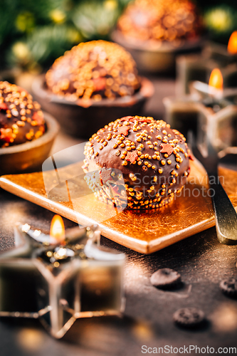 Image of Small chocolate pastry cakes for Christmas with candles and ornaments