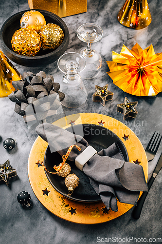 Image of Glamorous black and gold place setting with modern plates for New Years Eve and Christmas