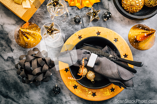 Image of Glamorous black and gold place setting with modern plates for New Years Eve and Christmas