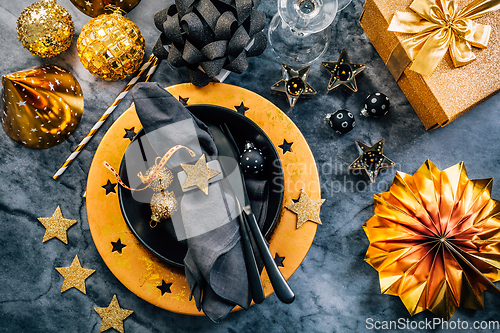 Image of Glamorous black and gold place setting with modern plates for New Years Eve and Christmas