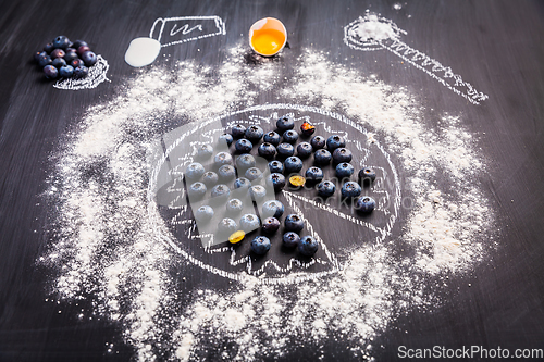 Image of Baking concept - ingredients for blueberry pie, sprinkled wheat flour circle
