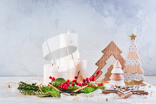 Image of Christmas decoration with candles and wooden Christmas trees