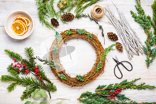 Image of Steps of making christmas door wreath, top down view of florist's worktable