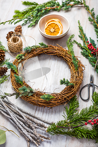 Image of Steps of making christmas door wreath, top down view of florist's worktable