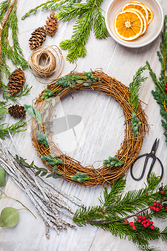 Image of Steps of making christmas door wreath, top down view of florist's worktable