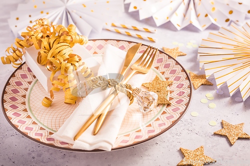 Image of Festive place setting for Christmas and New Year with paper  fans in golden tone