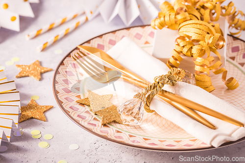 Image of Festive place setting for Christmas and New Year with paper  fans in golden tone