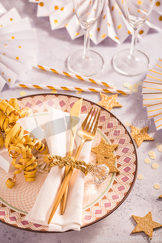 Image of Festive place setting for Christmas and New Year with paper  fans in golden tone