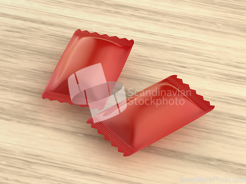 Image of Two red packagings for hard candies on wooden table