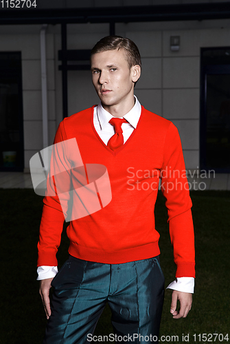 Image of Portrait of an attractive young businessman in urban background wearing red jacket and red tie. Looking to the camera. Classic style