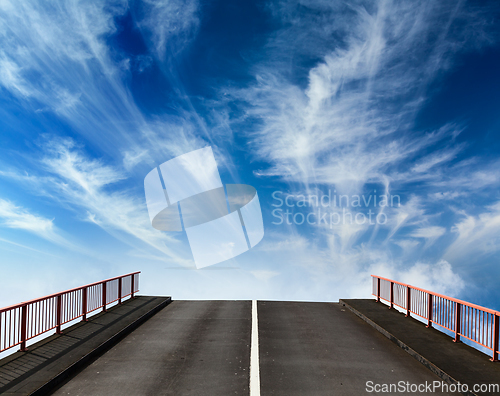 Image of Asphalt road going into sky with clouds