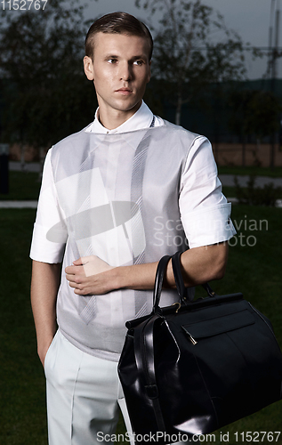 Image of Portrait of an attractive young businessman in urban background wearing suit and necktie. Looking to the camera. Classic style. Studio shot