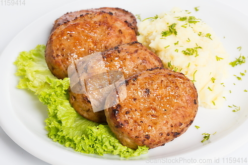 Image of Three fried breaded cutlet with lettuce and mashed potatoes on white background