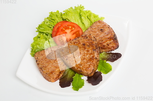 Image of Three fried breaded cutlet with lettuce and tomatoes on white background