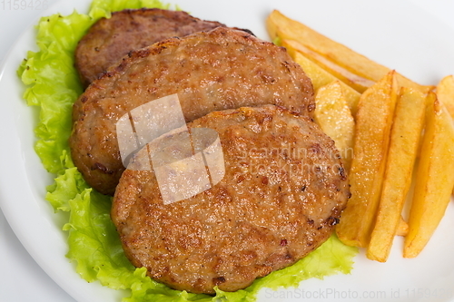 Image of Three fried breaded cutlet with tomatoes and french fries on white background