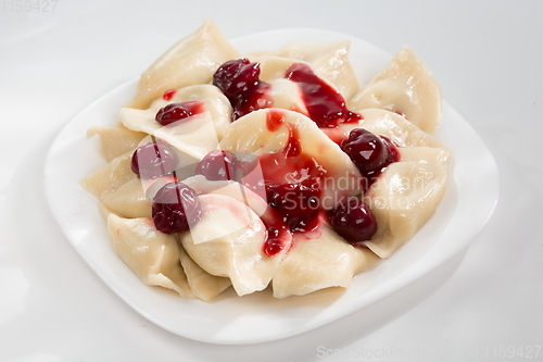 Image of Dumplings with cherry with red sauce.