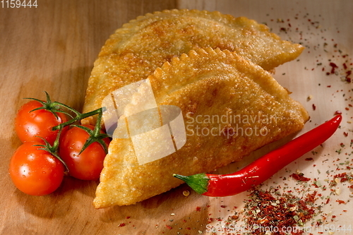 Image of Cheburek - fried pie with meat and onions. Traditional dish of many turkic and mongolian peoples. Tomato juice.