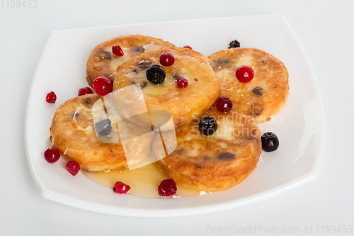 Image of Cottage cheese pancakes. homemade traditional Ukrainian dish syrniki with honey and sour cream.