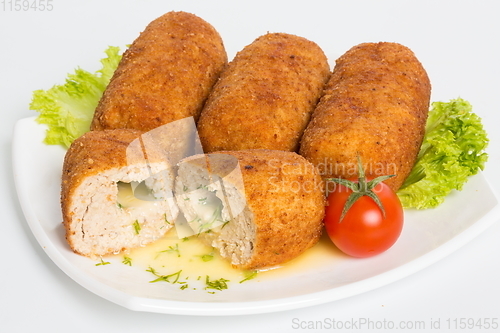 Image of Four fried breaded cutlet with lettuce, tomatoes and cucumbers on white background