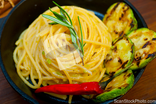 Image of italian spaghetti pasta with zucchini sauce on iron skillet