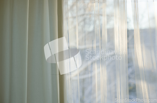 Image of curtains hang in front of window