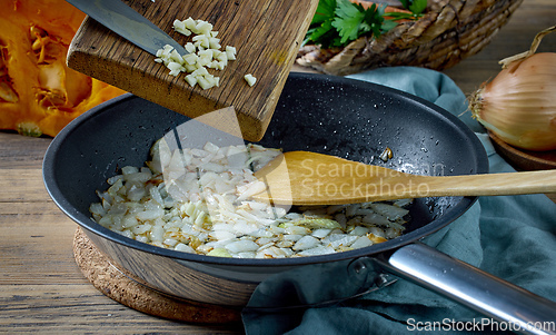 Image of fresh chopped garlic is added to fried onions