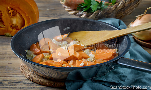 Image of sliced carrot and onion on pan