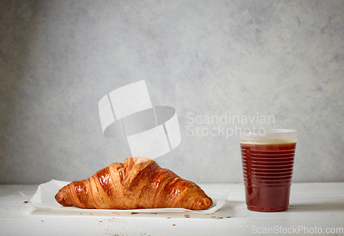 Image of freshly baked croissant and coffee