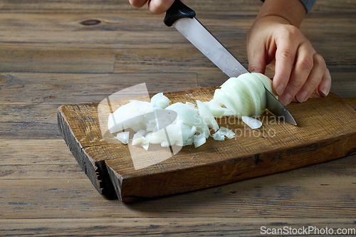 Image of the cook cuts the onion