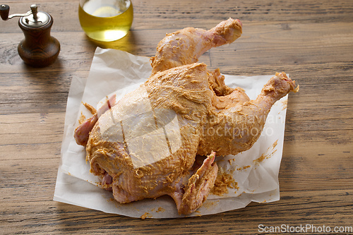 Image of raw chicken covered with spicy butter 