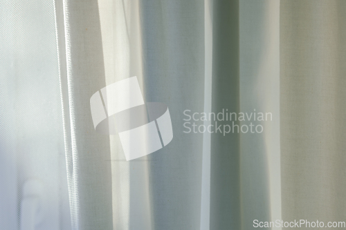 Image of curtains hang in front of window