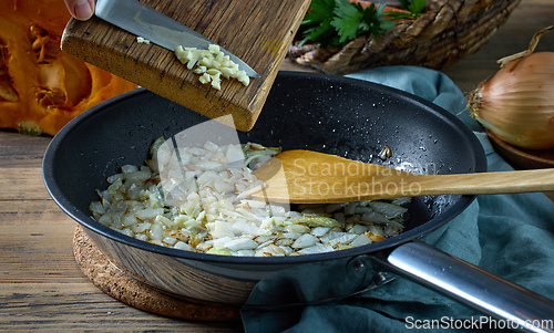 Image of fresh chopped garlic is added to fried onions