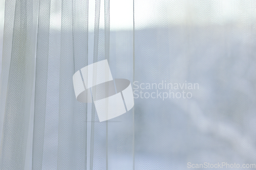 Image of curtains hang in front of window