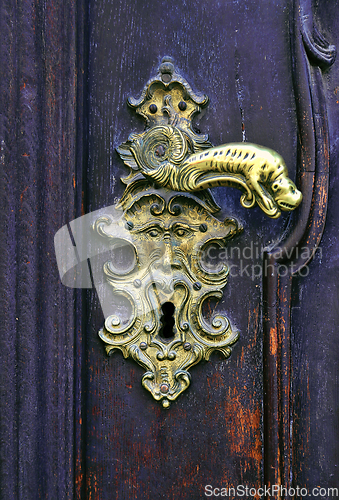 Image of Vintage wooden door with decorative handle and keyhole