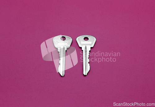 Image of Two silver keys to english lock on bright crimson background