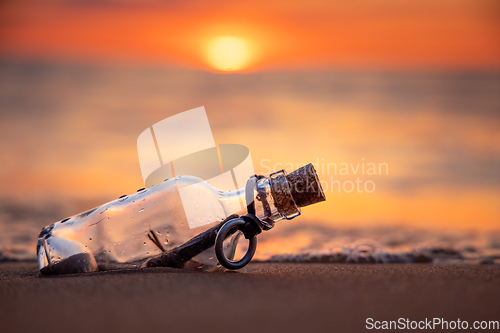 Image of Message in the bottle against the Sun setting down