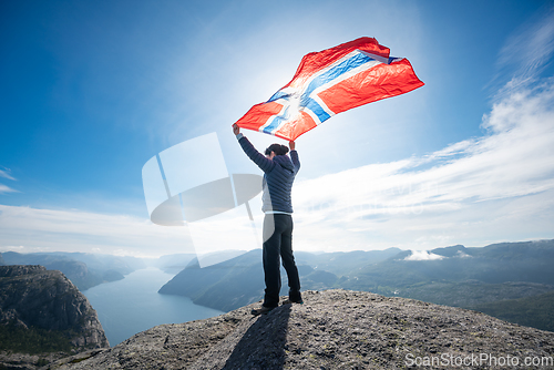 Image of Woman with a waving flag of Norway on the background of nature