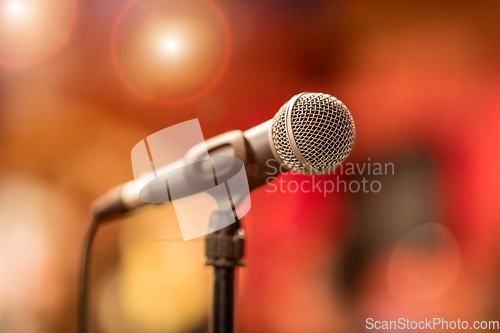 Image of Microphone on stage against a background of auditorium.