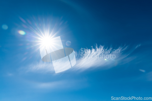 Image of Clouds in the blue sky. Bright midday sun illuminates the space.