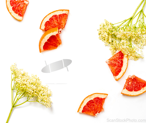 Image of Pieces of grapefruit and elderflower on a white background