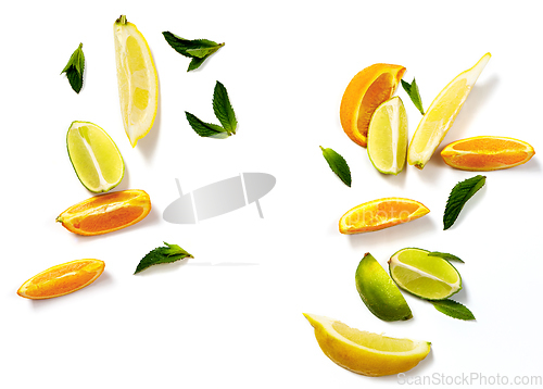 Image of Sliced citrus fruits and mint leaves on a white background