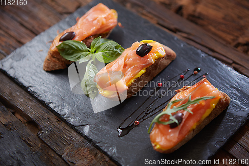 Image of The tasty bruschetta with salmon on black stone